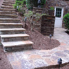 Natural flagstone is on the concrete pad on the steps and deck. Premier Stone&reg; is on the vertical surfaces. 